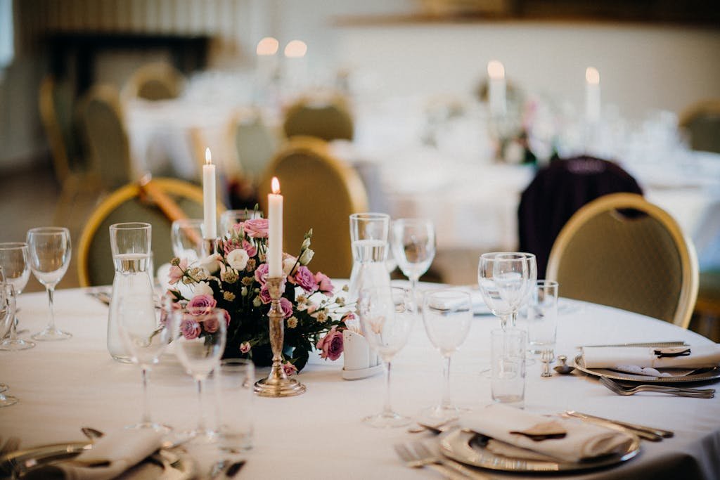 Elegant table setting for a wedding with a floral centerpiece and candles.